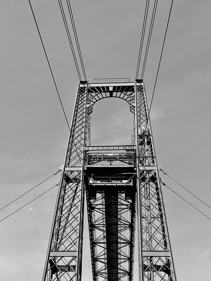 Black and white view of the iconic Vizcaya Bridge in Getxo, Spain, showcasing its engineering marvel.